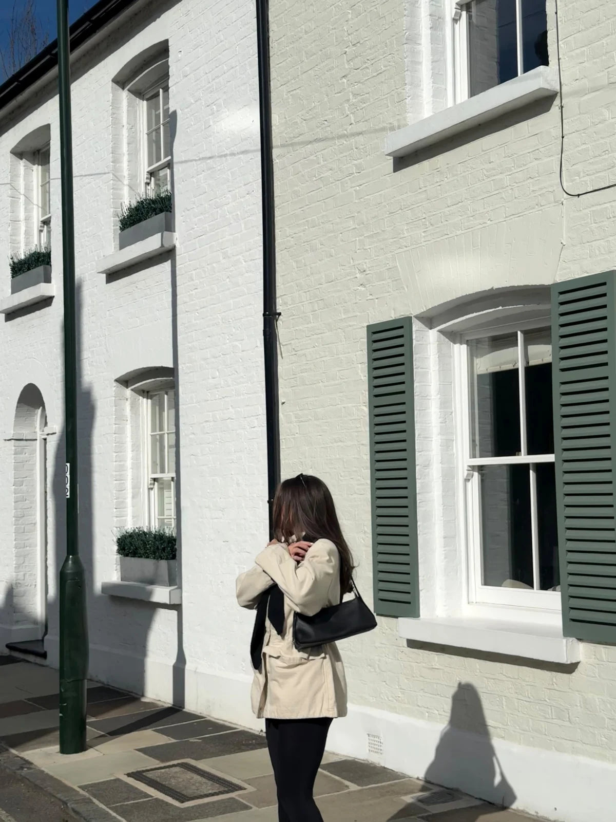Woman walking along a city street with a black KÖVI bag