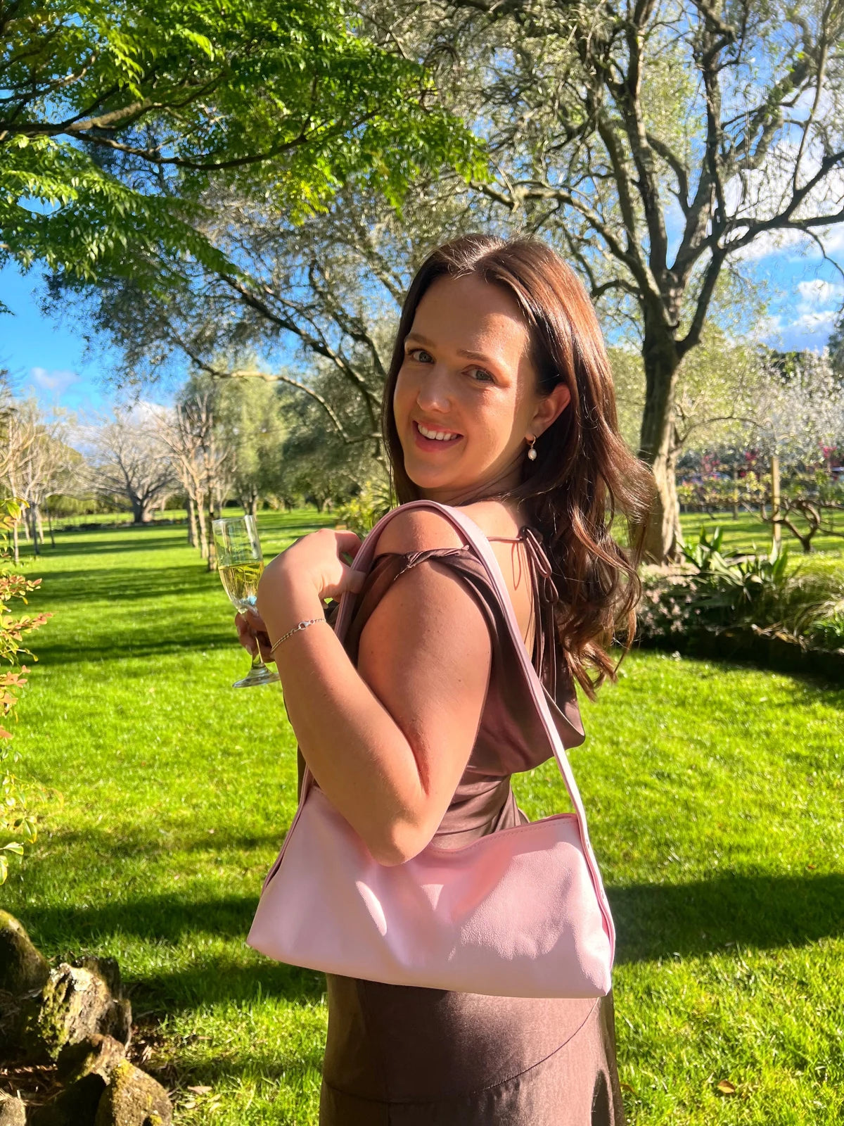 Woman carrying a pink Mini Lola bag in a park